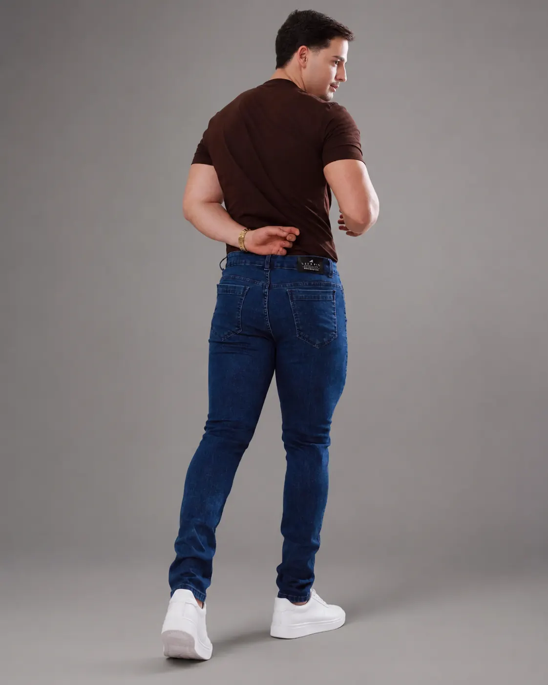 Calça jeans masculina vista de costas com camiseta marrom